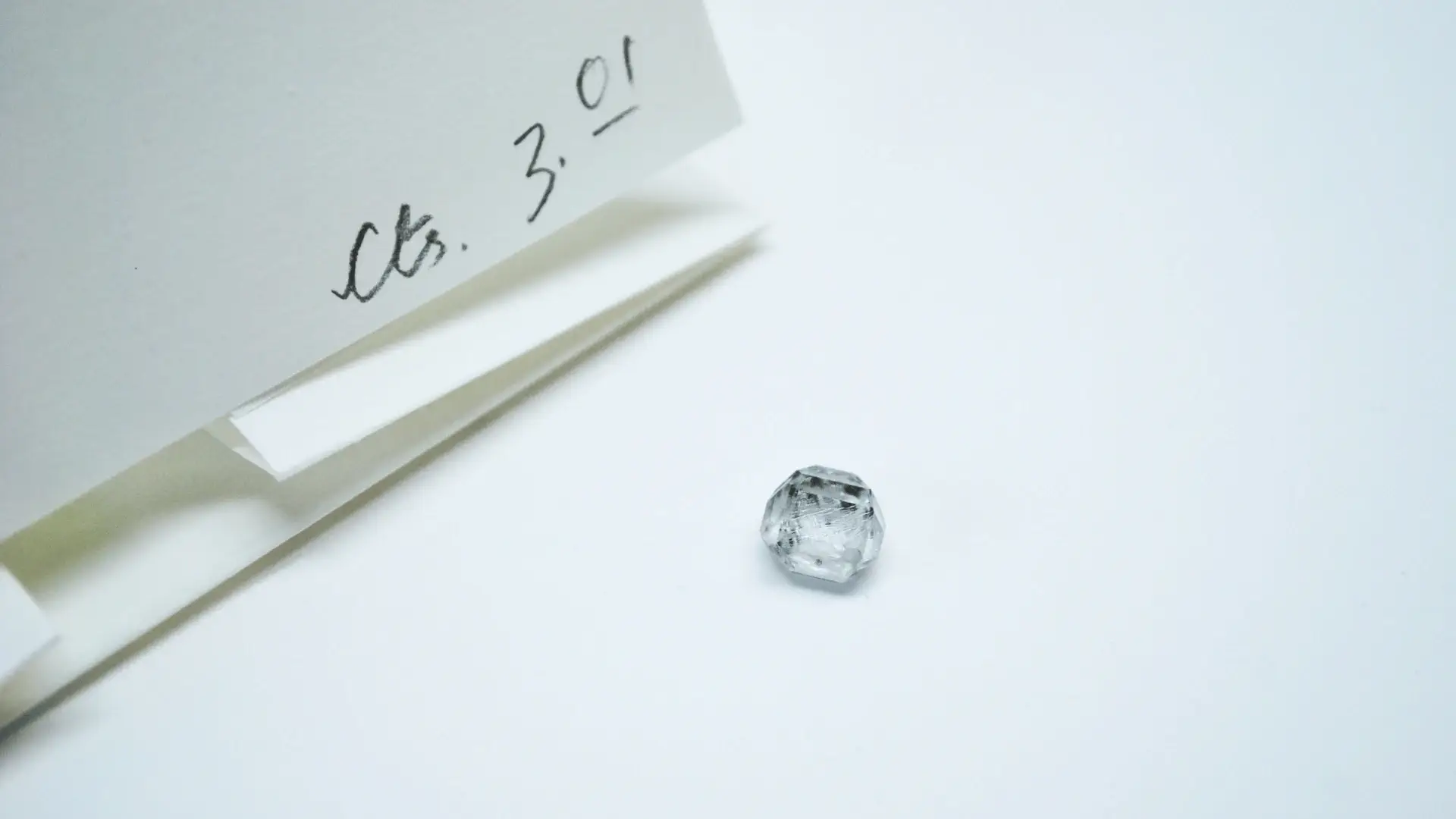 GIA diamond grading certificate next to a loose certified diamond